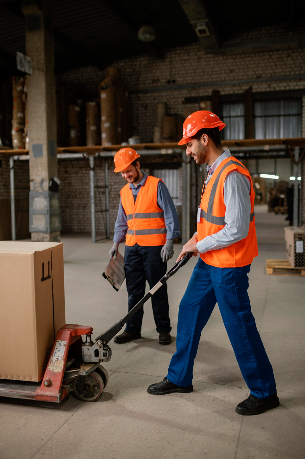 Working working in the warehouse operating a pallet truck