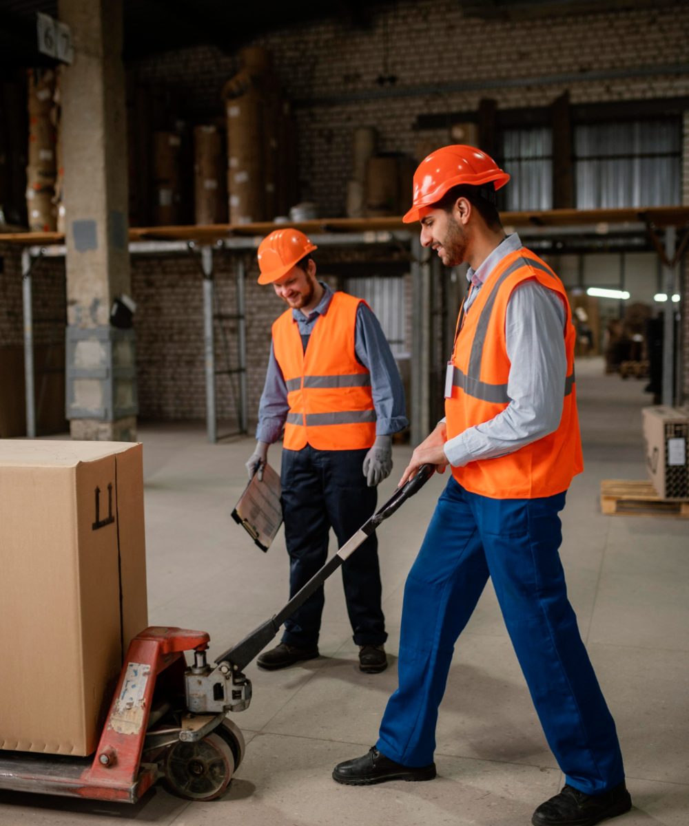 Working working in the warehouse operating a pallet truck